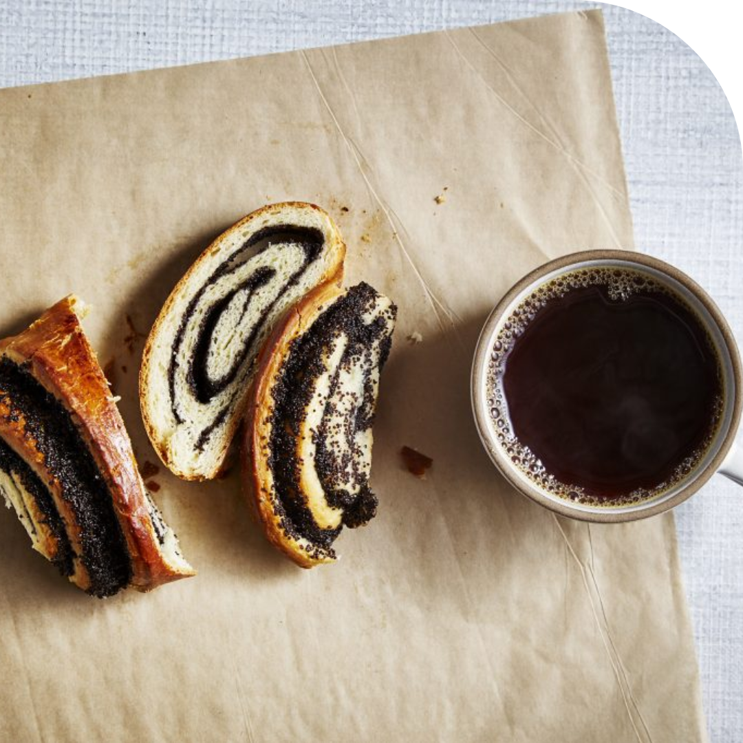 overhead photo of a poppyseed pastry and cup of coffee