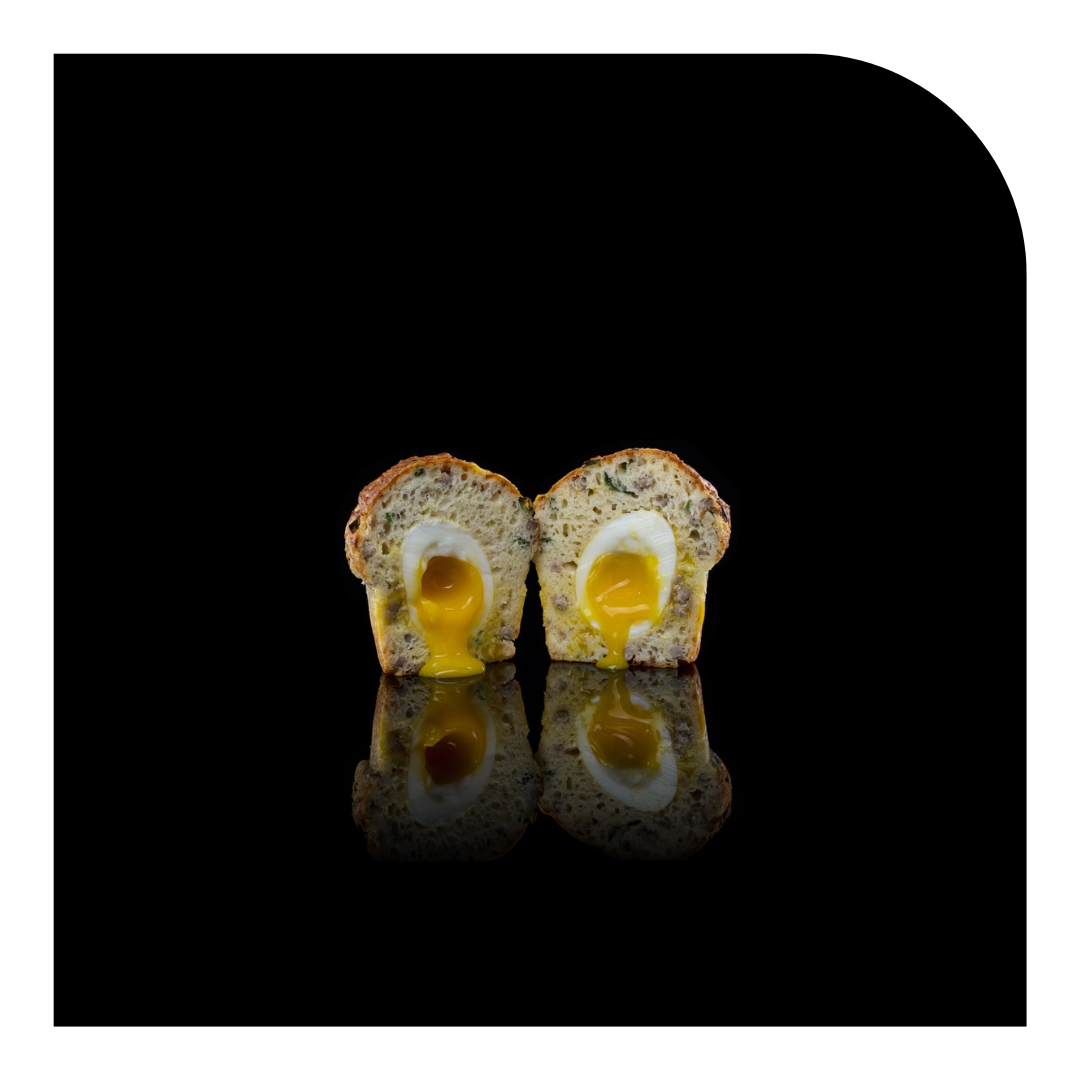 photo of a muffin with an egg, on a dramatic black background