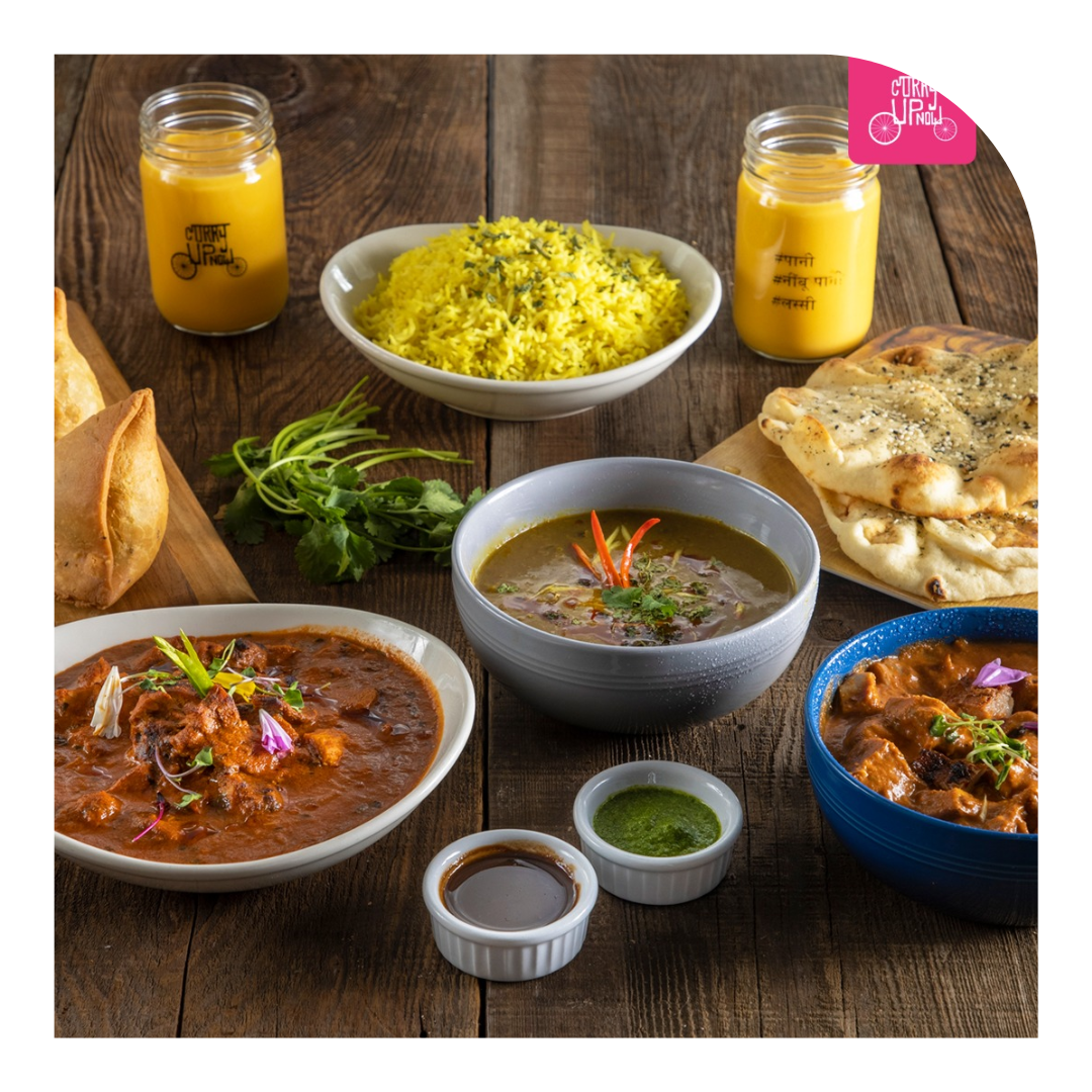 photo of a spread of indian food, curries, and drinks