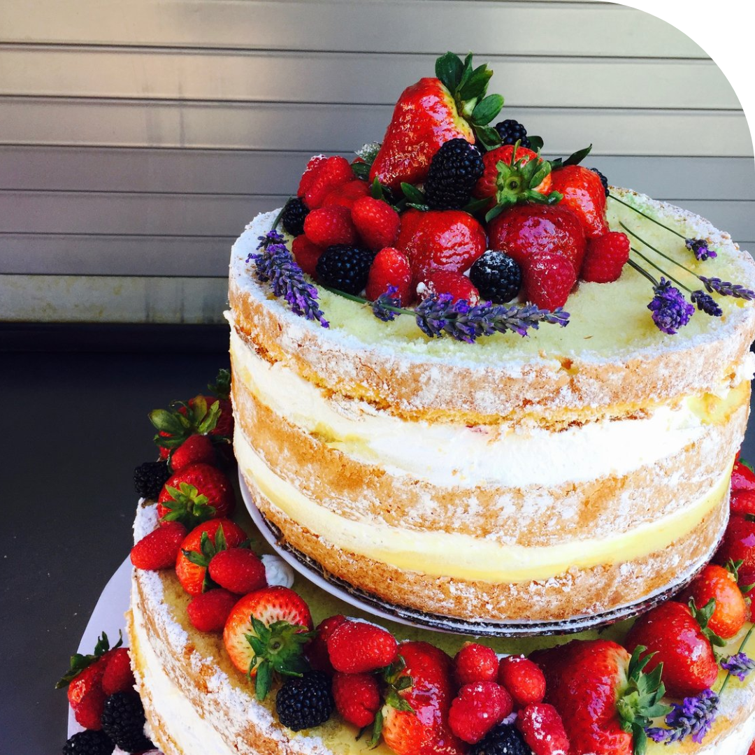 photo of a two tier cake with berries on top