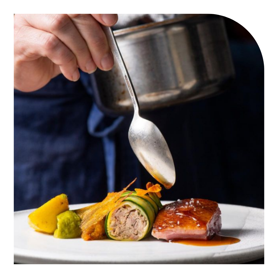 photo of a plate of food with a spoon of sauce being poured