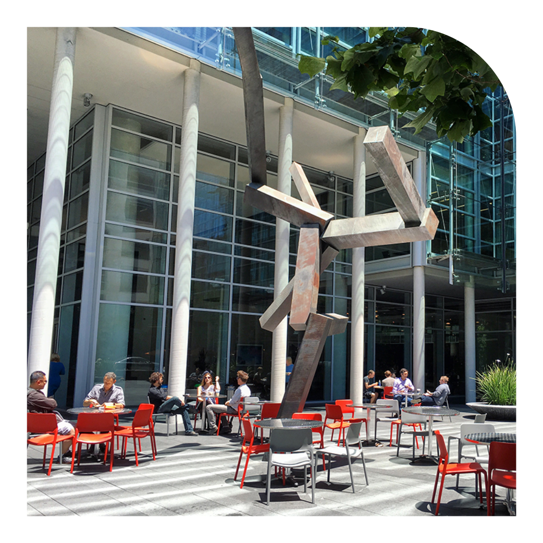 photo of a courtyard with cafe tables and a sculpture