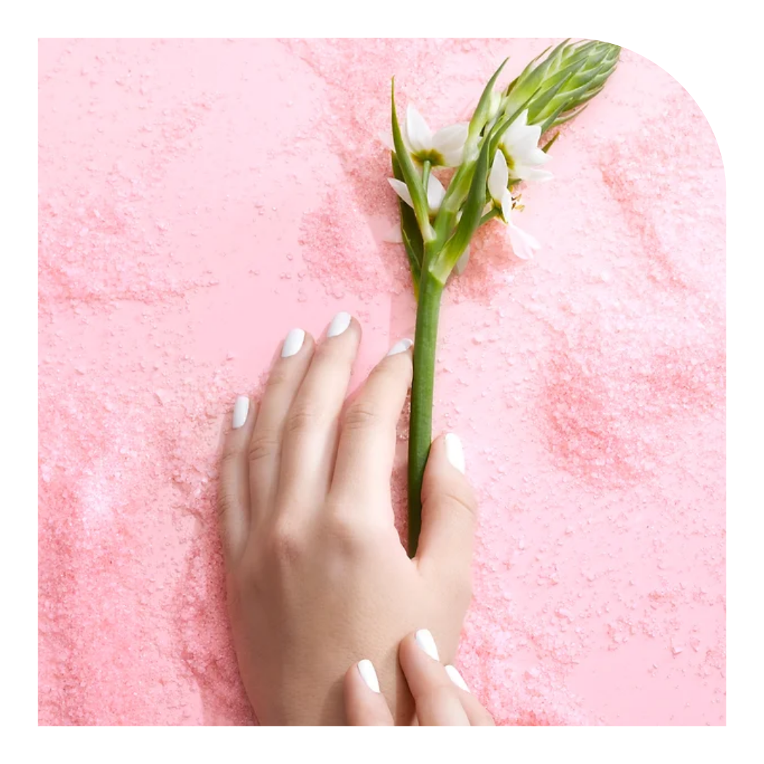 photo of a hand with pink painted nails holding a flower