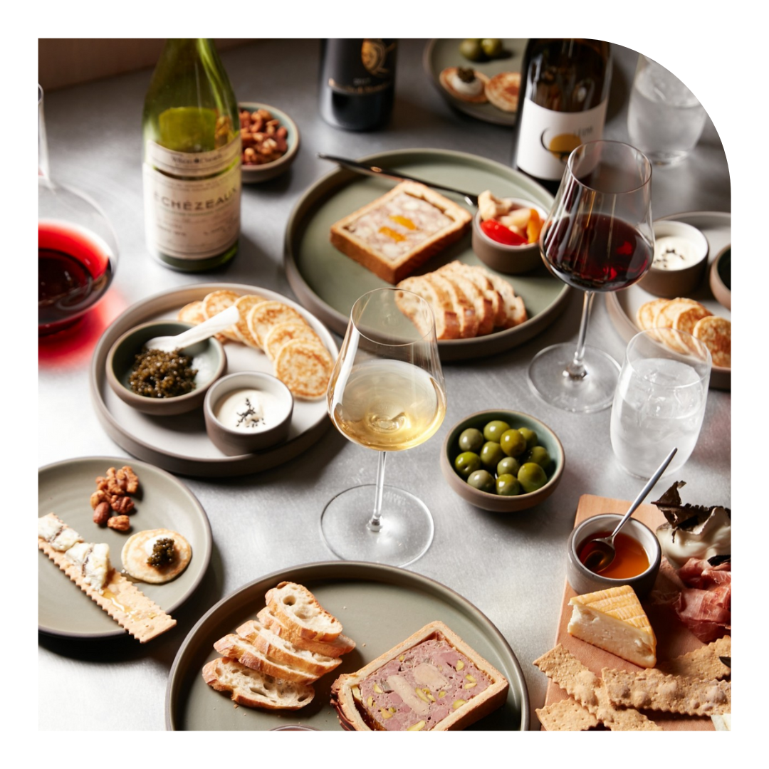 overhead photo of glasses of wine and food on a table