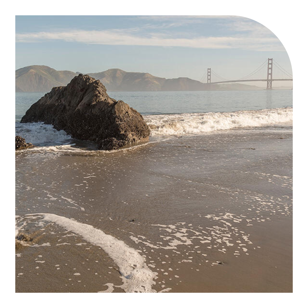 photo of a beach with the Golden Gate Bridge in the background