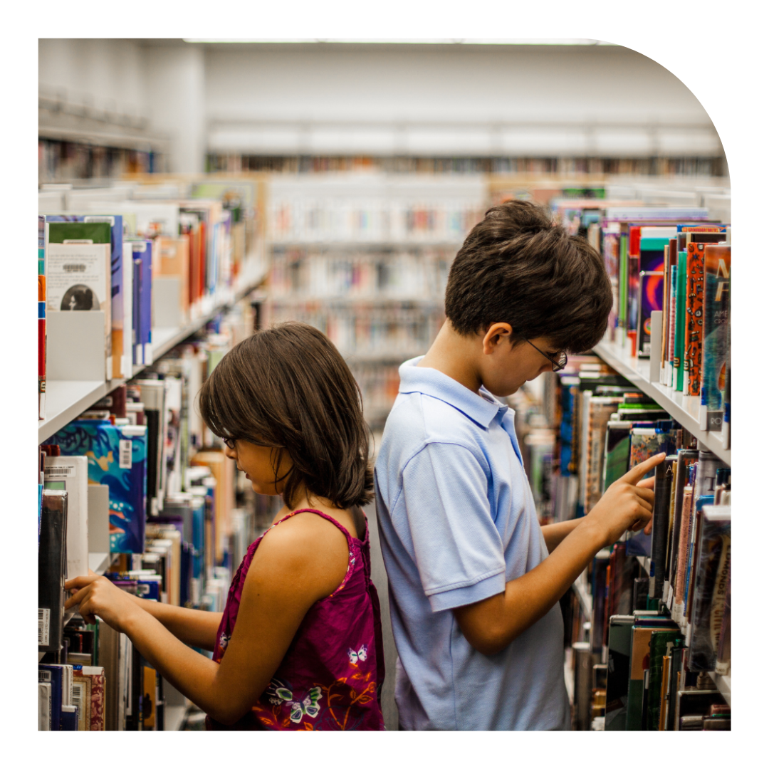 photo of two kids reading in a library
