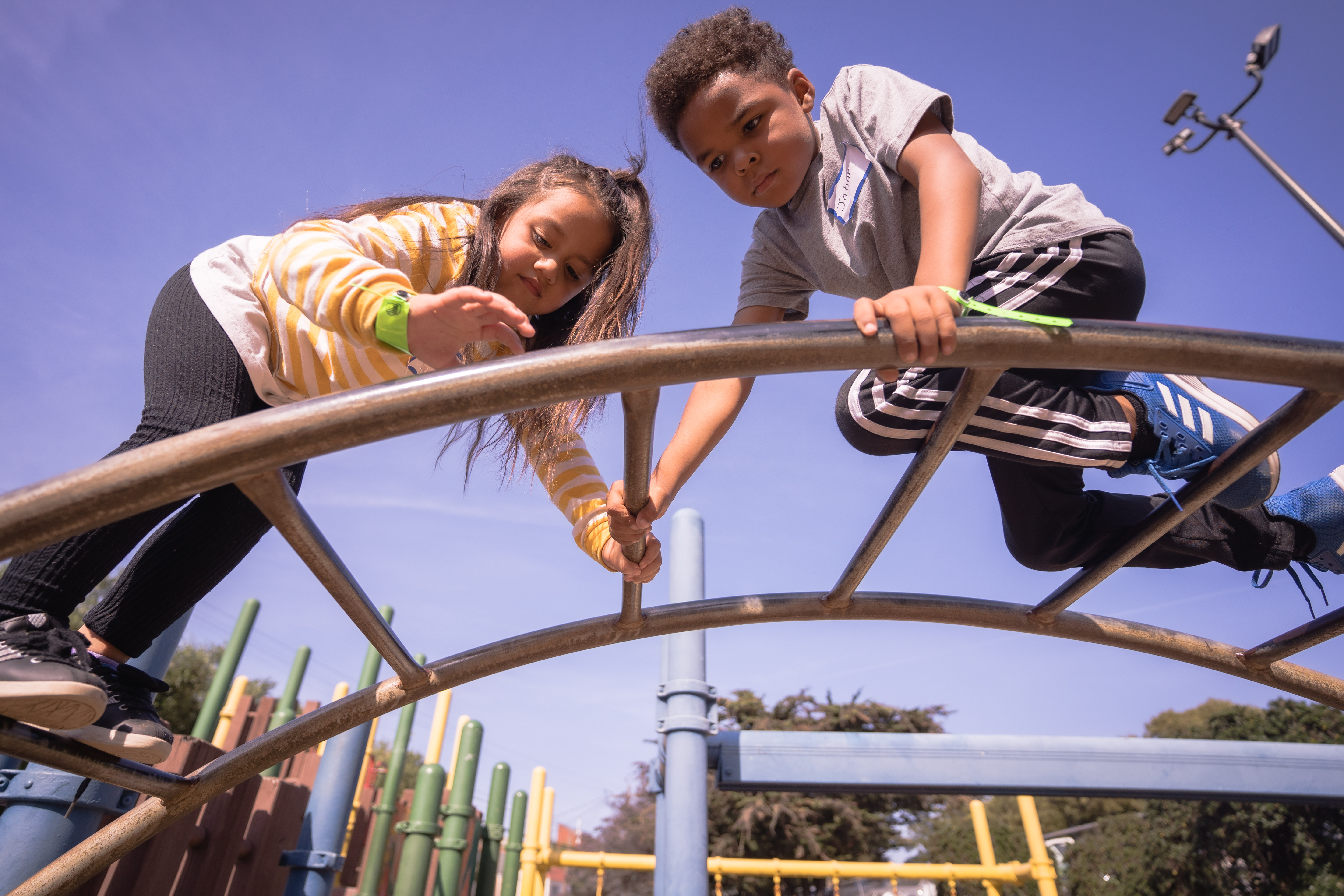 Two kids climbing in a playground