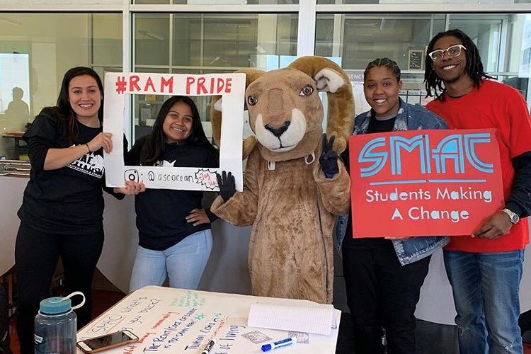 A group of City College of San Francisco students standing on either side of a person in a ram mascot costume