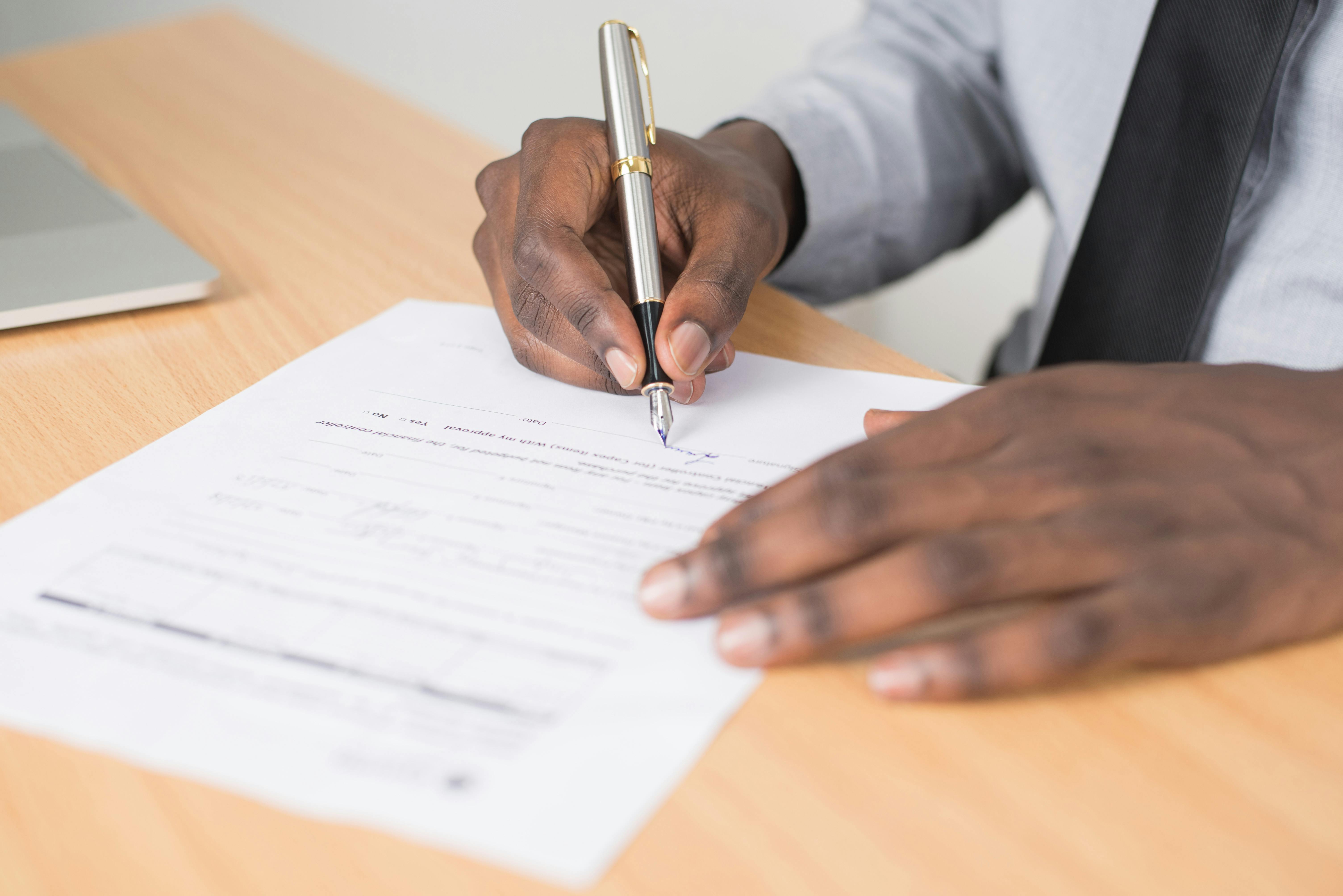 a person signing a paper