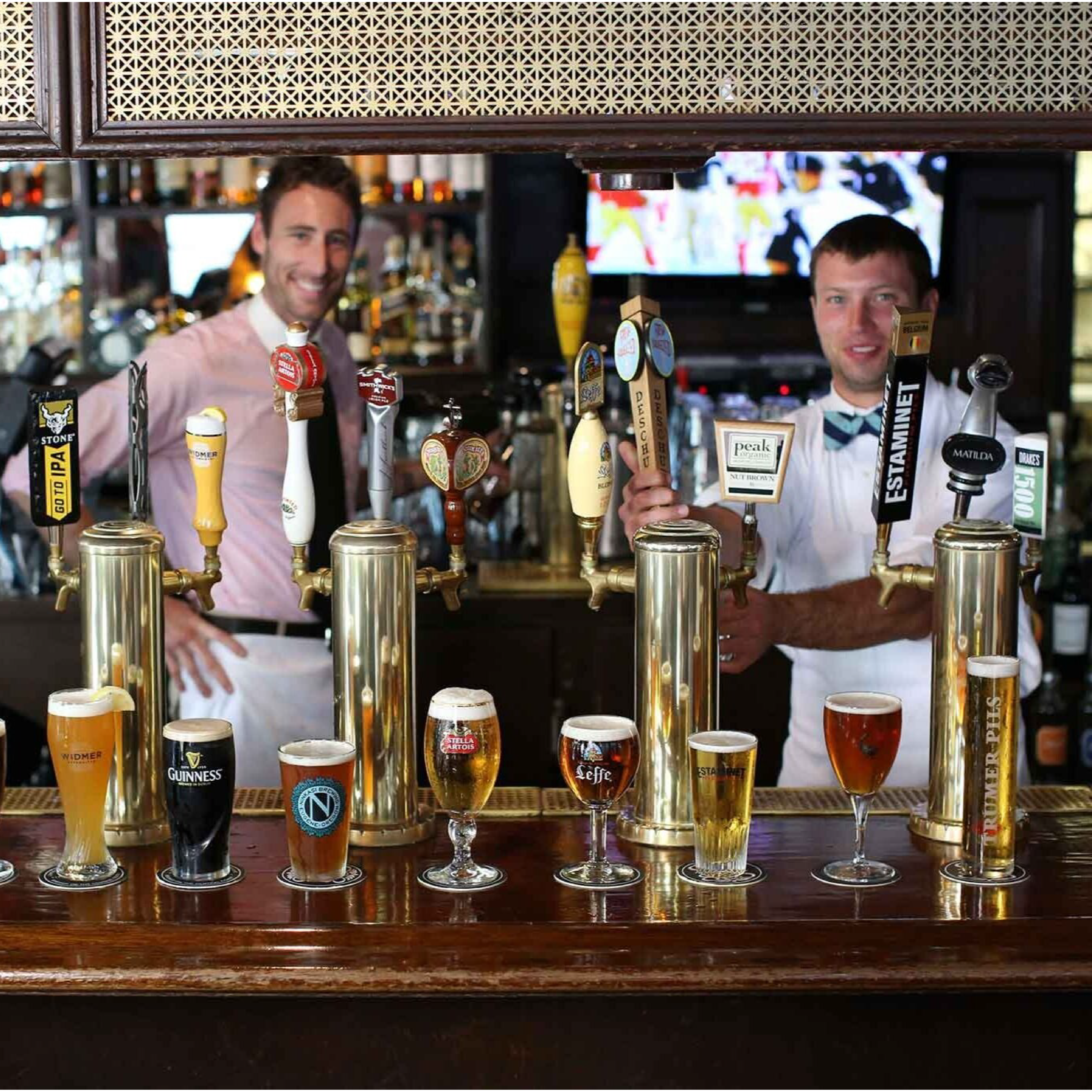 A image of two men in front of draft beer