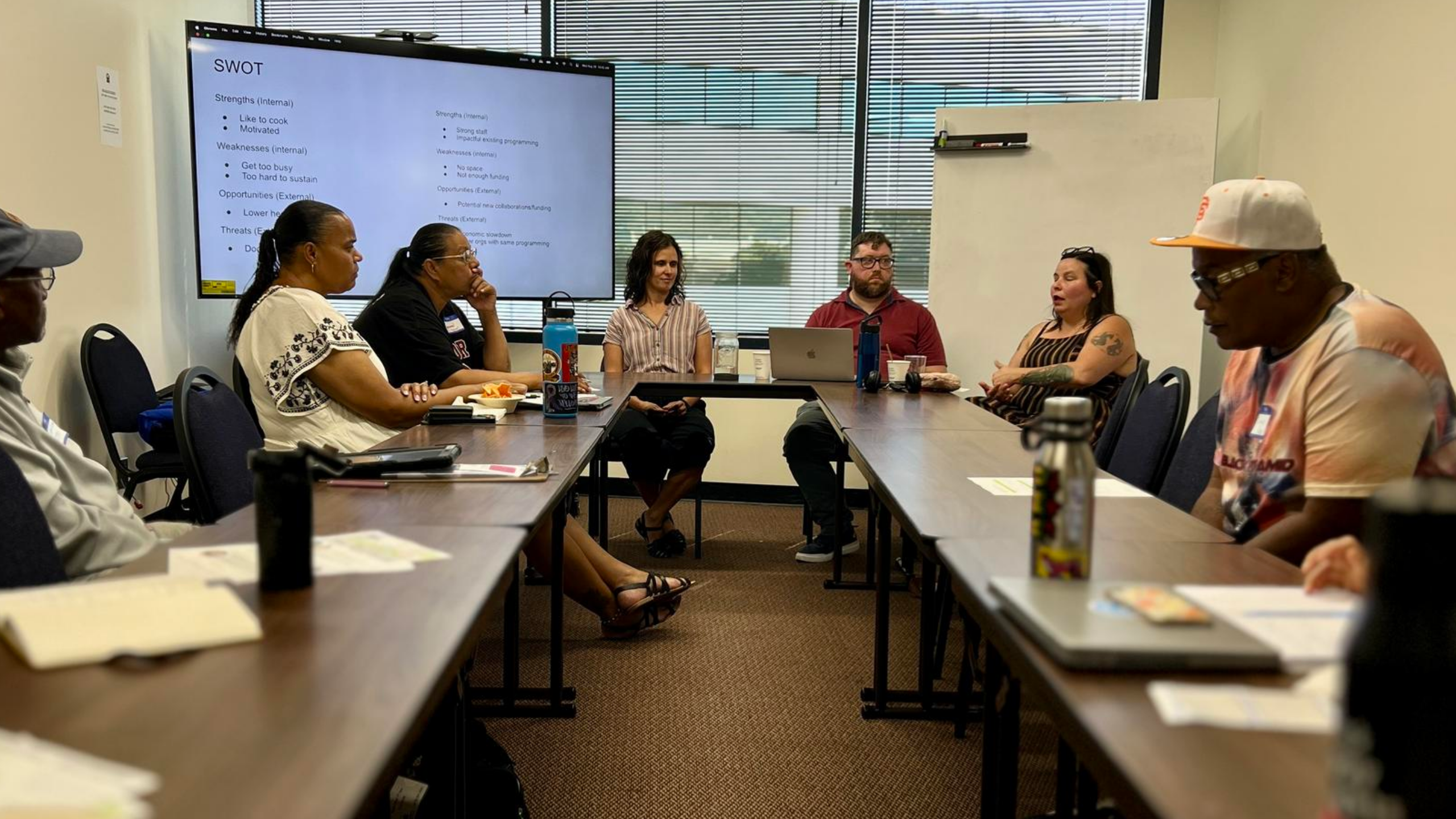 diverse people sitting around a conference room in a workshop