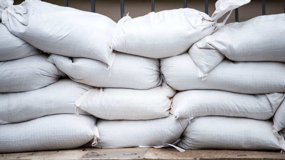 White sandbags for flood defense sitting on top of one another. 