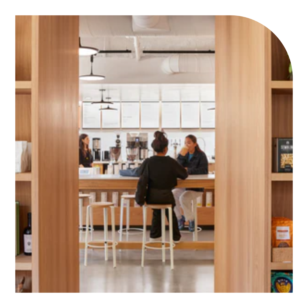 photo of the back of a person seated at a counter drinking coffee