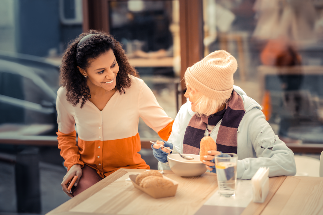 Joyful women smiling while helping another woman