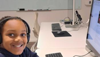 Smiling youth with headphones enjoying computer time