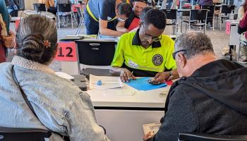 A volunteer helps someone apply for U.S. citizenship during a free workshop