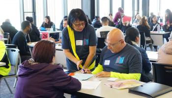 Workshop participant gets help filling out the citizenship application from a volunteer