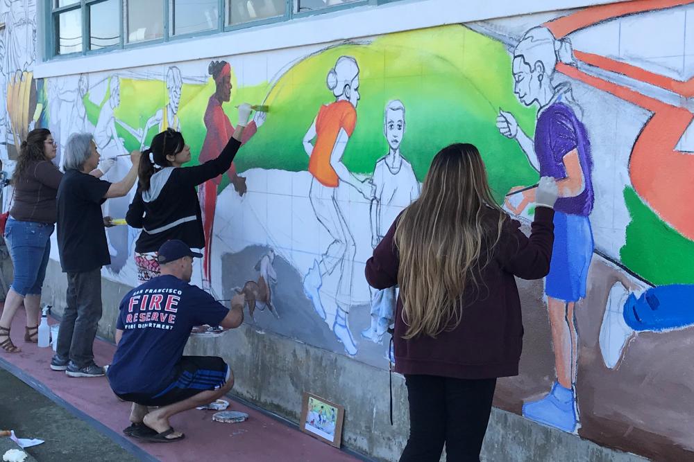 Community members painting the Treasure Island community mural