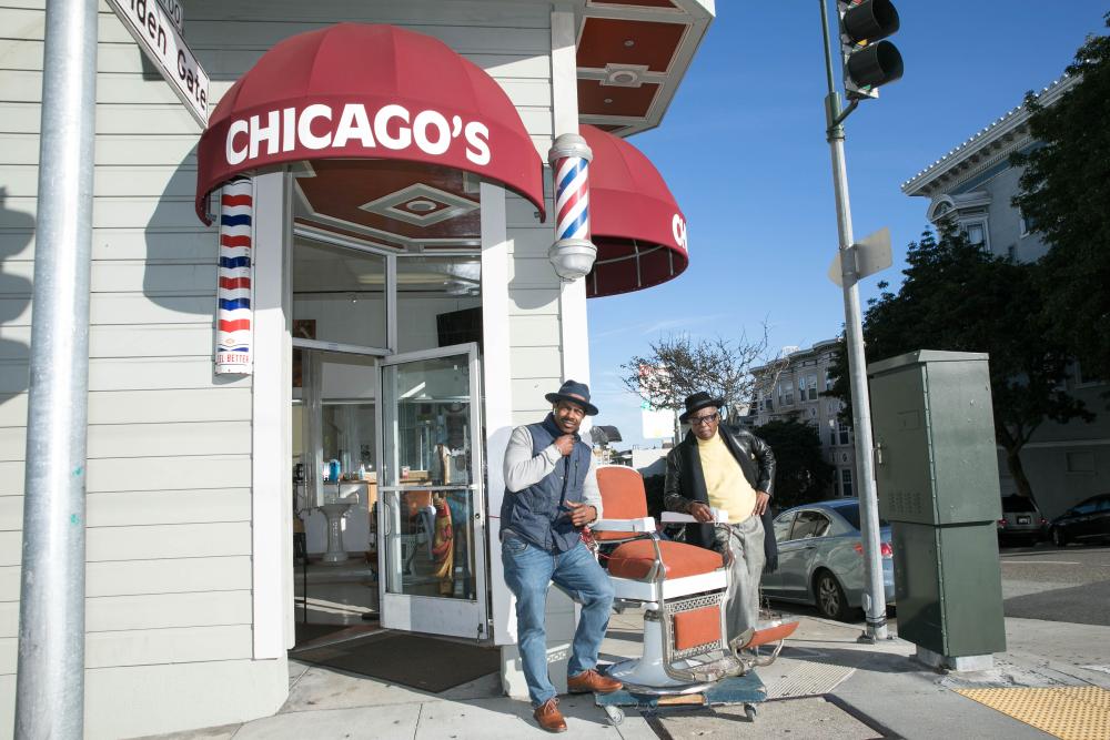 Chicago Barber Shop owner Rob Harlin standing in front of his storefront. 
