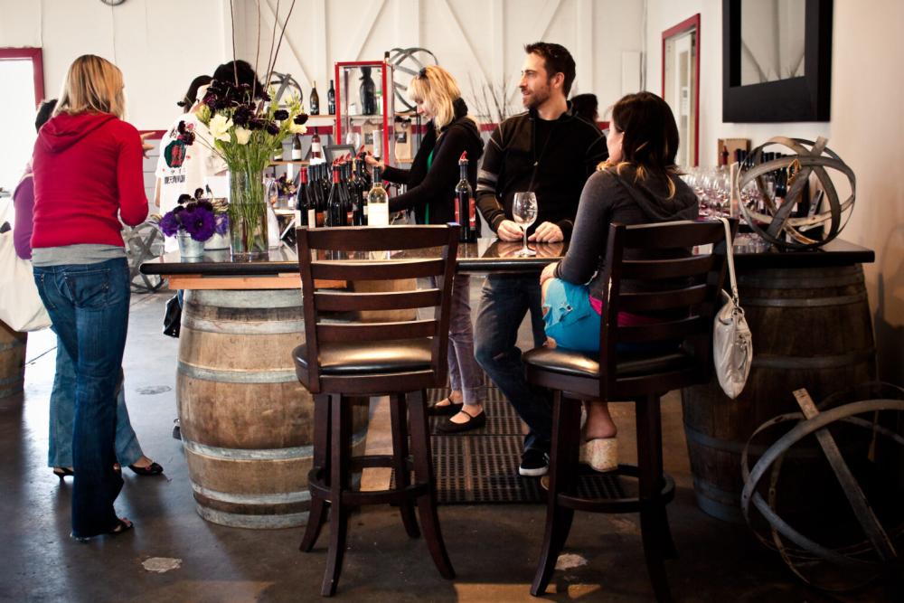 Customers drink wine and converse inside Treasure Island Wines winery