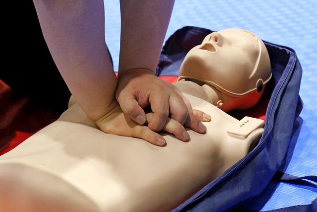 person giving CPR to a practice Manikin 