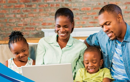 black family together on couch looking at laptop