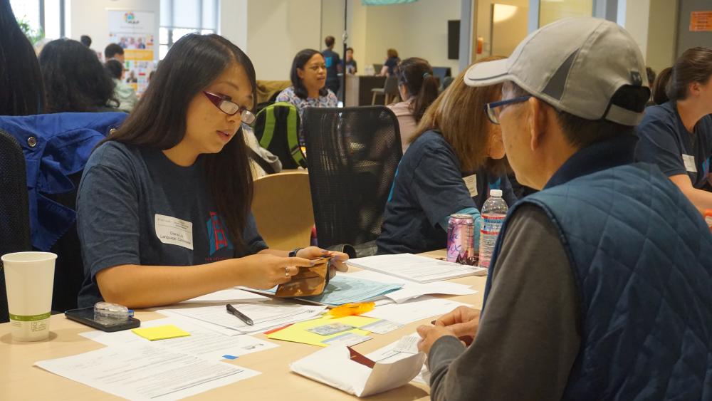 SF Pathways volunteer helps workshop participant fill out citizenship paperwork