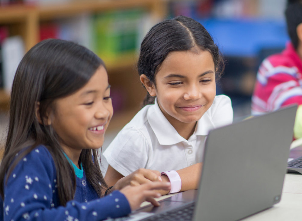 two girls using a laptop