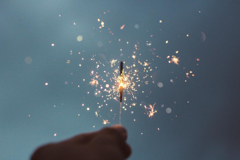 photograph of a hand holding a lighted sparkler