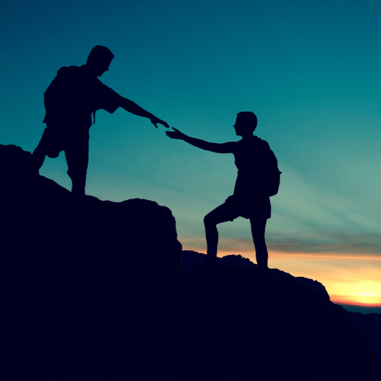 A silhouette of a person holding out a hand to another person