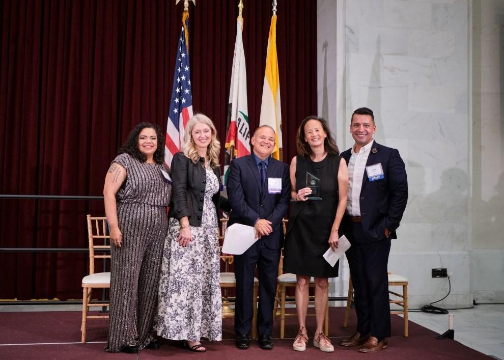 Immigrant Rights Commissioners present Katharine Gin of Immigrants Rising with a special recognition award at the Immigrant Leadership Awards event. 