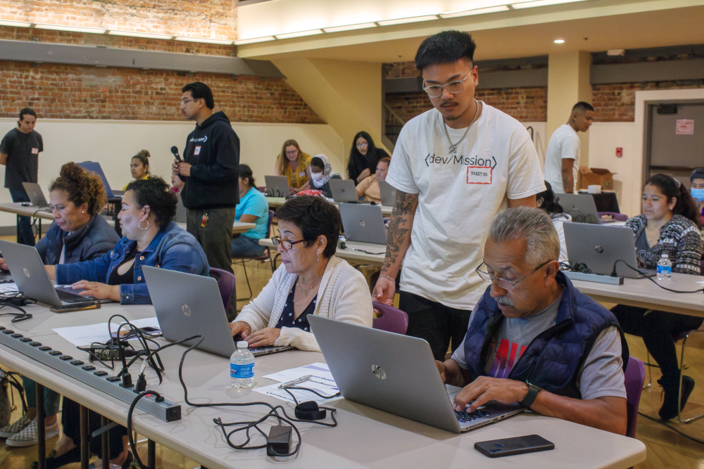 People learning on laptops in workshop