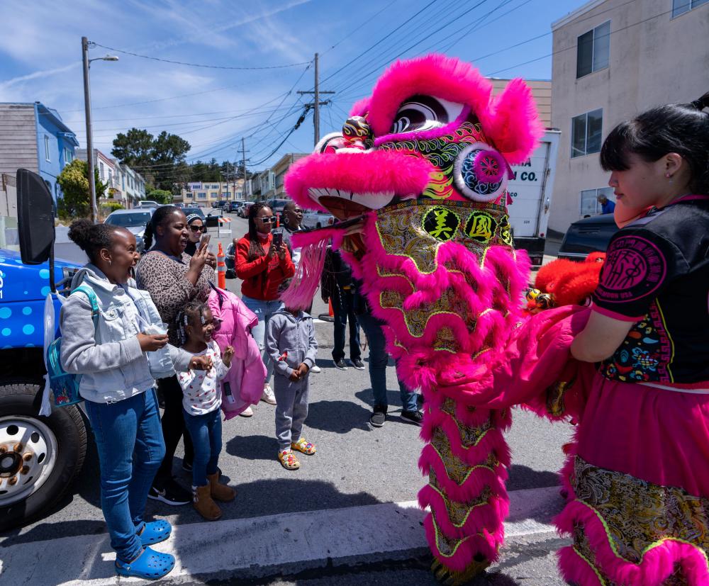 A family up close to a lion dancer