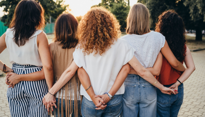 a group of people standing together with their arms around each other