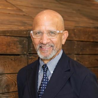 A man, smiling facing forward.