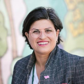 A woman, smiling, facing forward