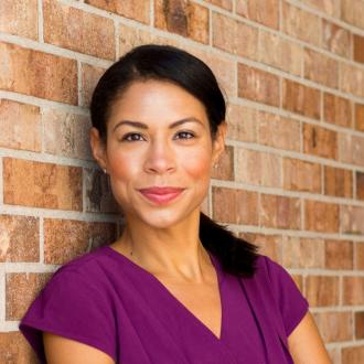 portrait of breanna zwart. she has a ponytail and is smiling, wearing a purple shirt.