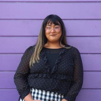 Asri Wulandari's headshot in black blouse, in front of purple background