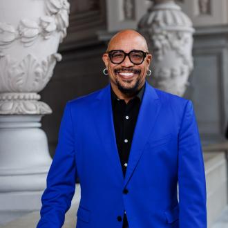 Photo of Ralph Remington, Director of Cultural Affairs, a Black man wearing a blue suit