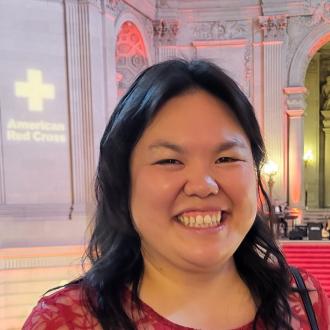 A woman dressed in red smiles at city hall