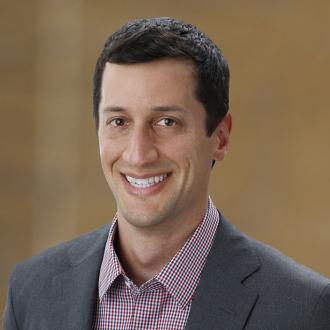 a man looking into the camera, 3/4 profile, smiling